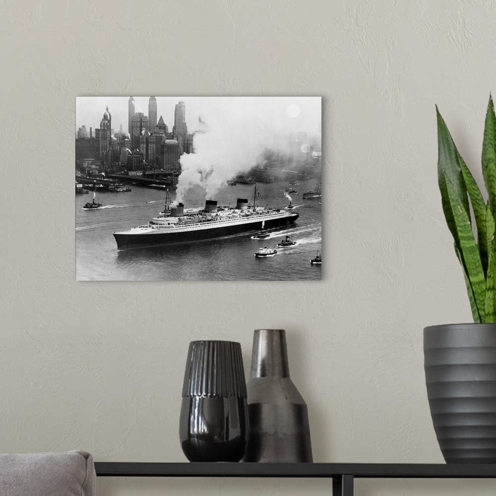 A modern room featuring Tugboats follow alongside the French turbine-electric ocean liner SS Normandie as it travels thro...