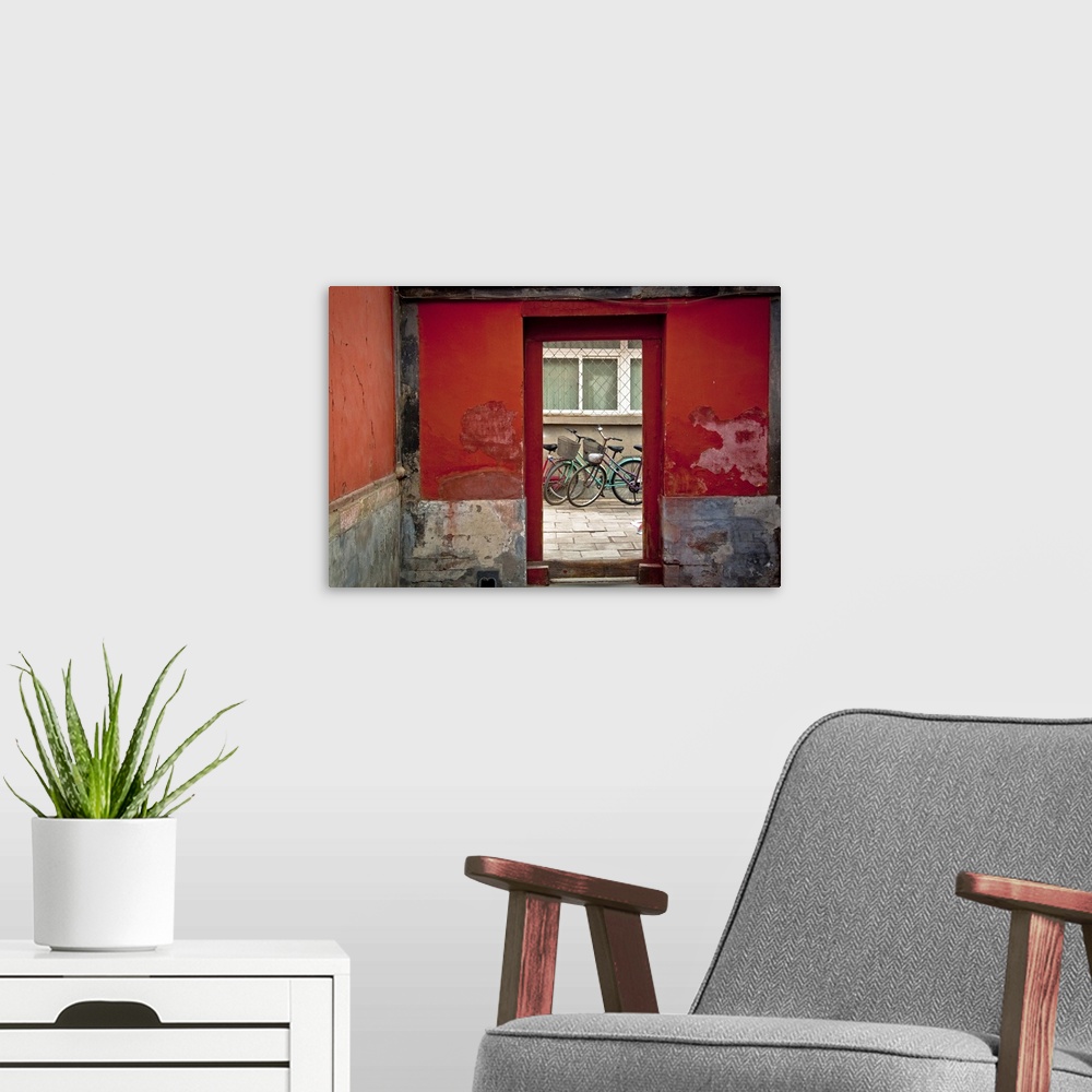 A modern room featuring Big, horizontal photograph of a clear glass doorway surrounded by red and grey cement walls.  Thr...