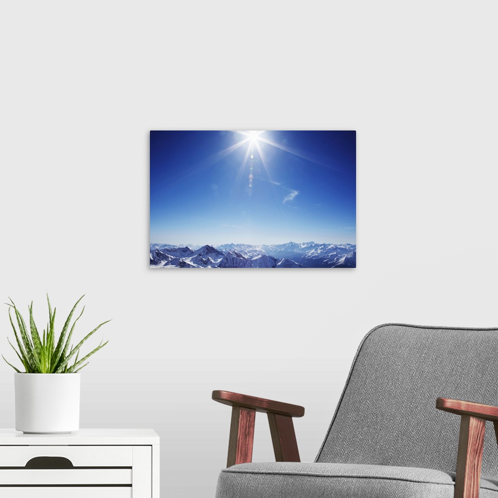 A modern room featuring Sun over snow covered mountains