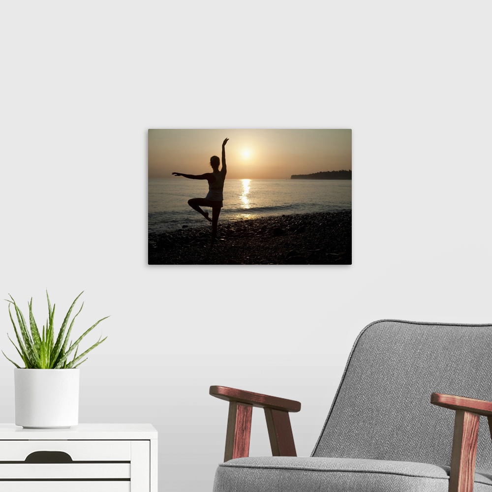 A modern room featuring Woman practicing ballet pose on the beach, sunrise