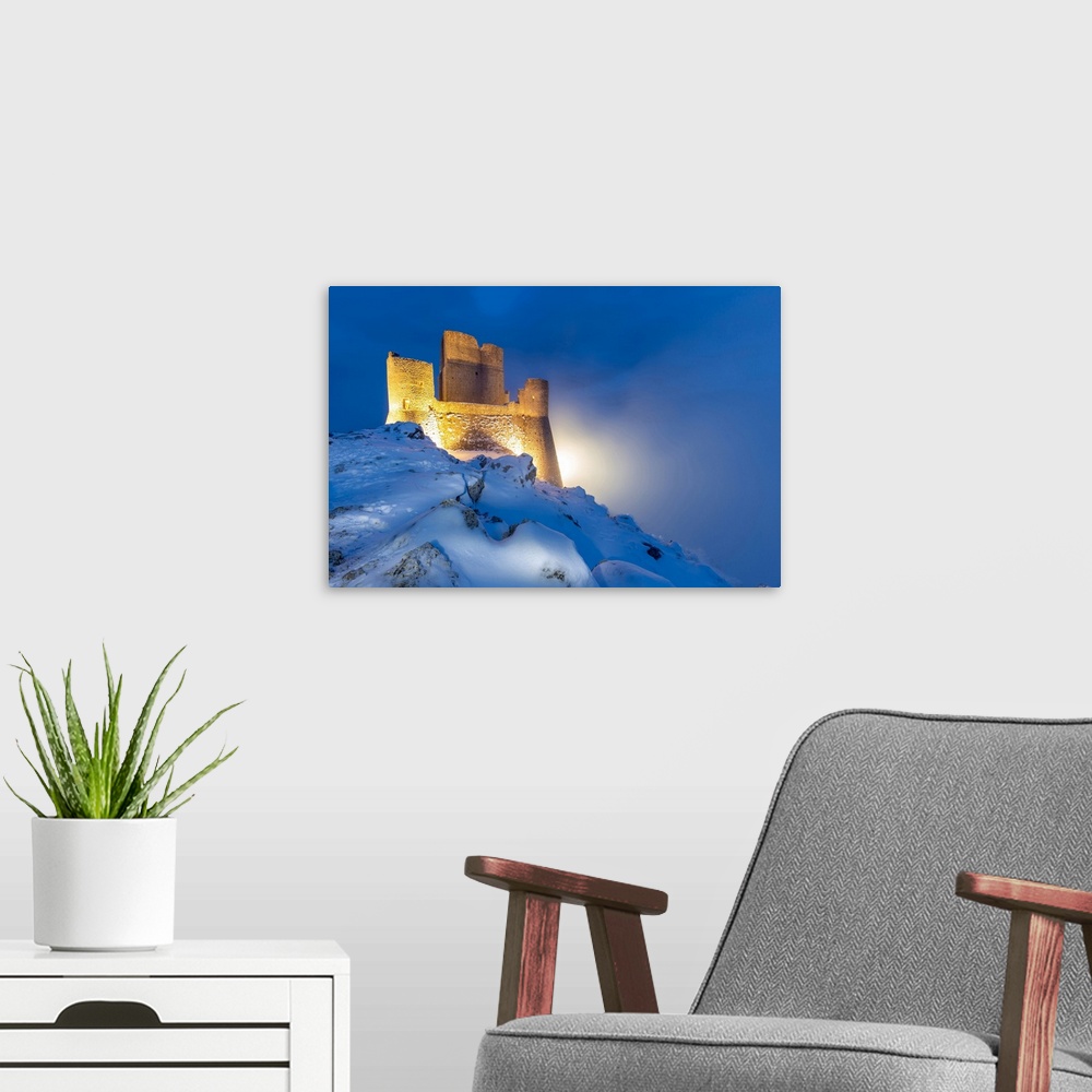 A modern room featuring Castle of Rocca Calascio in winter during the dusk-Europe, Italy, Abruzzo, Province of L'Aquila, ...
