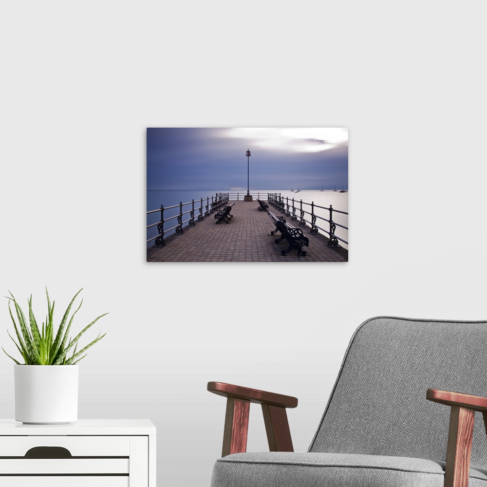 A modern room featuring England, Dorset, Swanage. Sunrise from the Banjo Jetty at Swanage, with the Isle of Wight just vi...