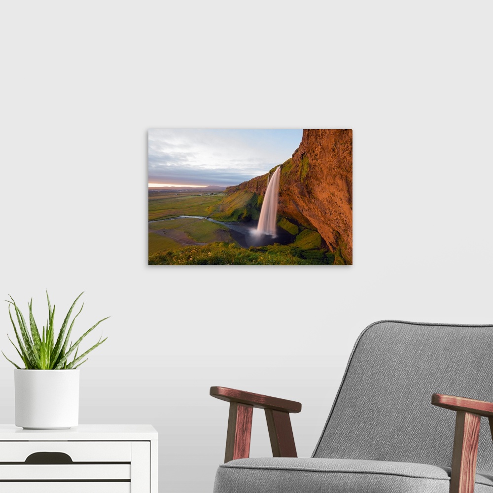 A modern room featuring Iceland, southern region, Seljalandsfoss waterfall, sunset.