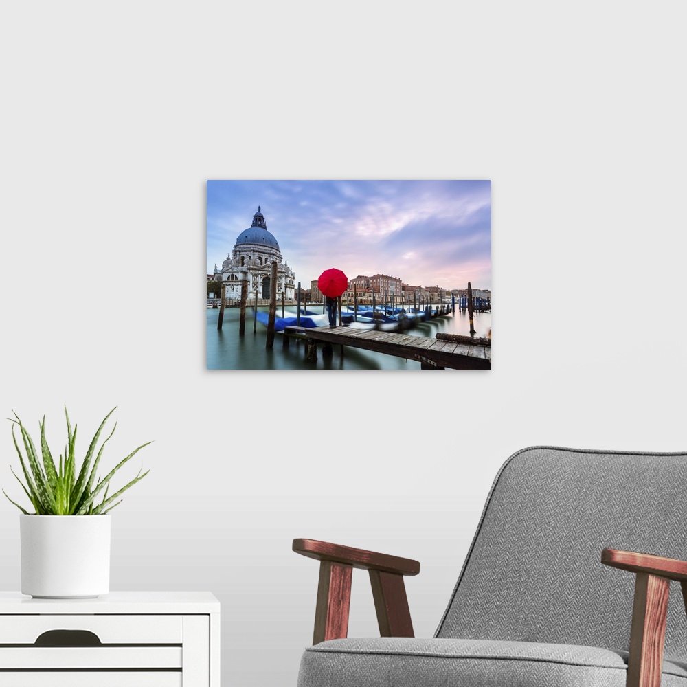 A modern room featuring Italy, Veneto, Venice. Santa Maria della Salute church on the Grand Canal, at sunset, woman stand...