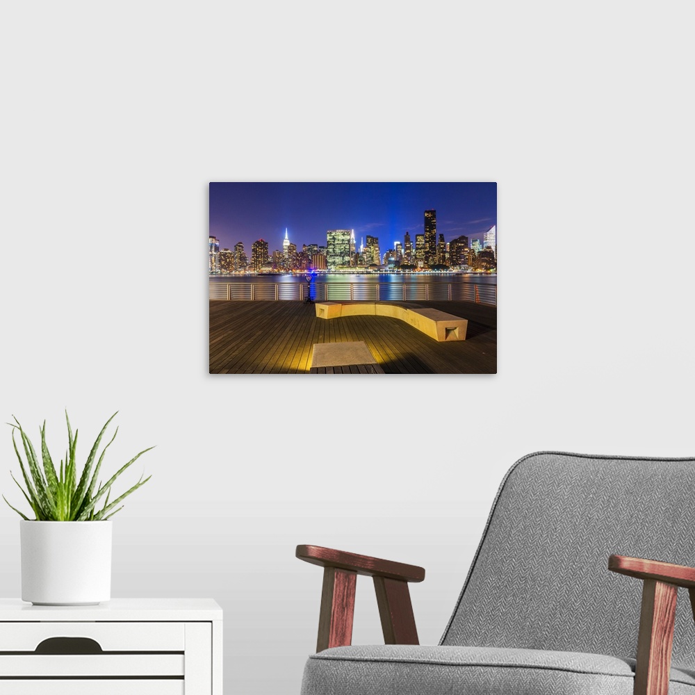 A modern room featuring Manhatten skyline at dusk from Gantry Plaza, New York, USA.