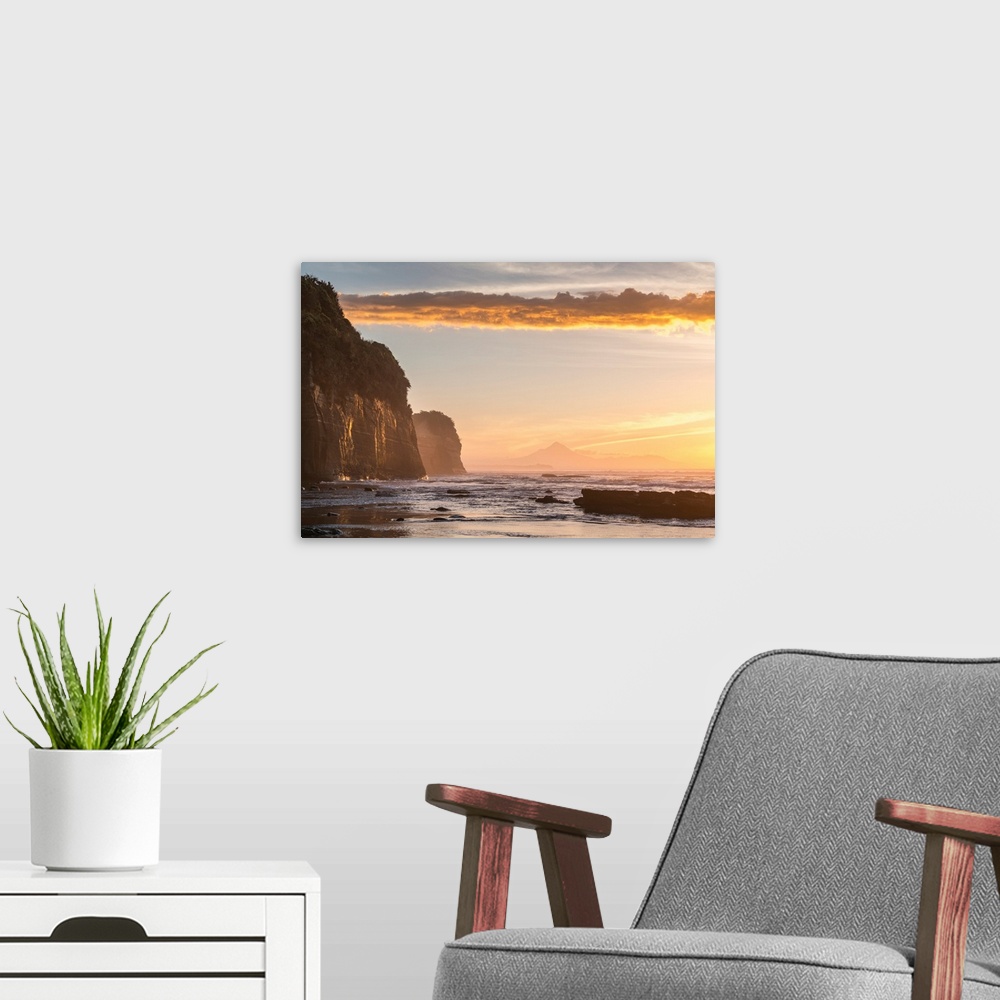 A modern room featuring Elephant rock and Mount Taranaki silhouette in the background, at sunset. Tongaporutu, New Plymou...