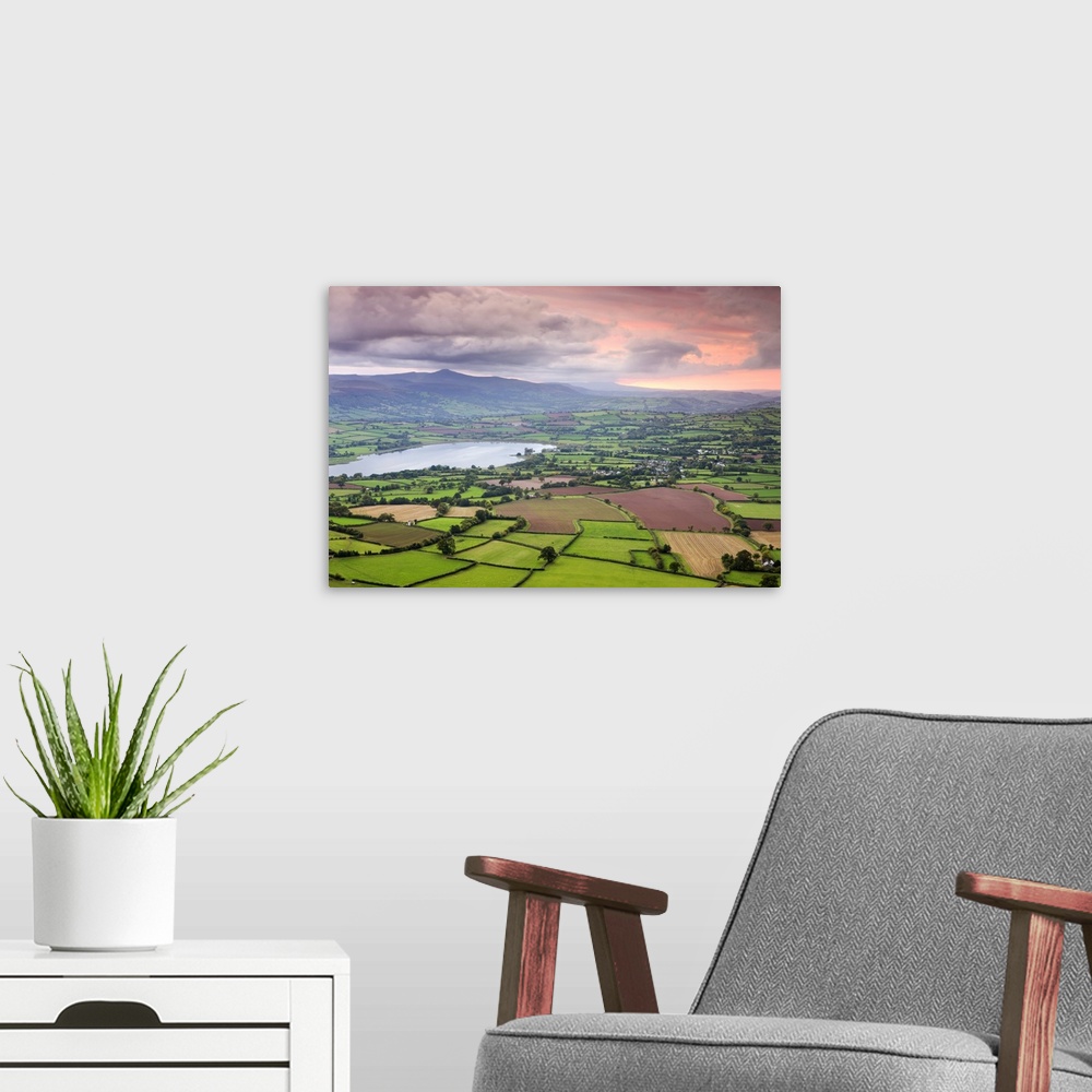 A modern room featuring Pink sunset above the Brecon Beacons mountain range and rural countryside near Llangorse, Brecon ...