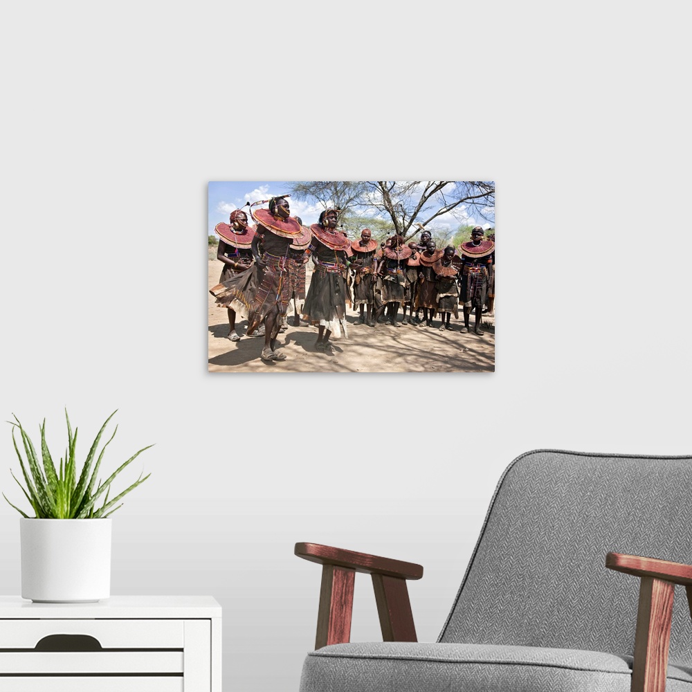 A modern room featuring Pokot women and girls dancing to celebrate an Atelo ceremony. The Pokot are pastoralists speaking...