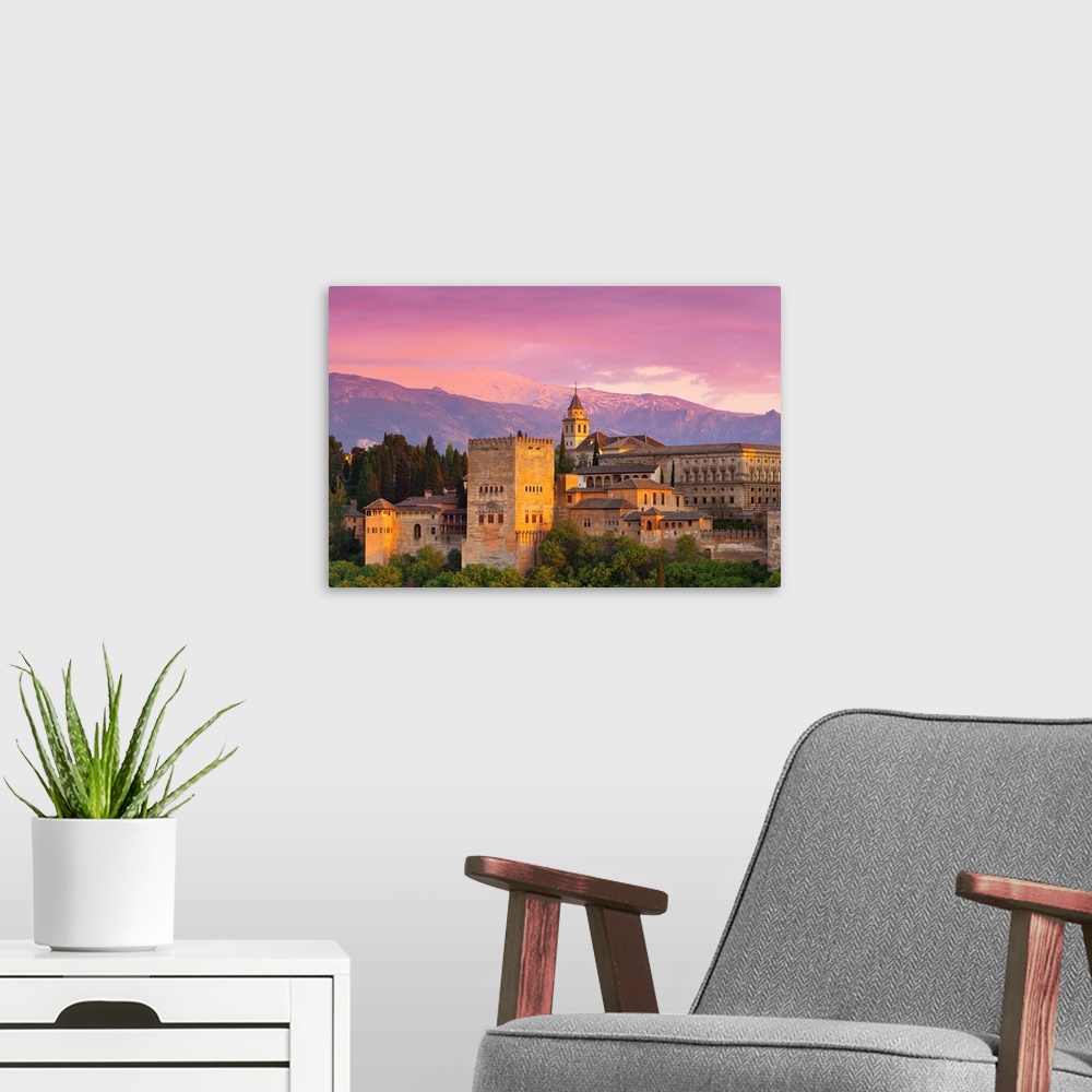 A modern room featuring The dramatic Alhambra Palace illuminated at sunset, Granada, Granada Province, Andalucia, Spain