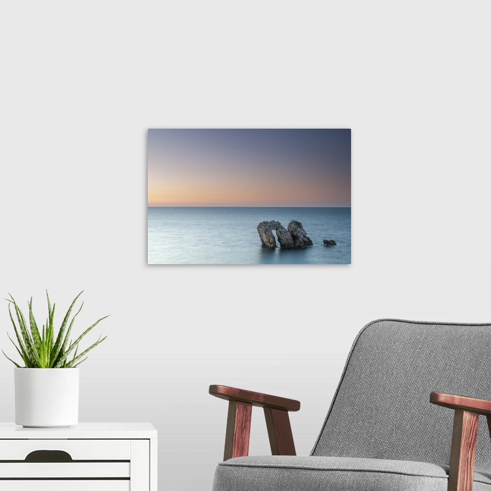 A modern room featuring Archway boulders in a blue ocean at sunset.
