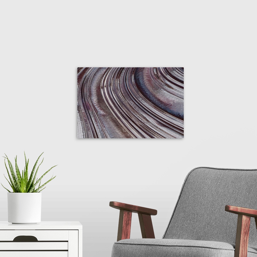 A modern room featuring Abstract photo on canvas of curving indentions.