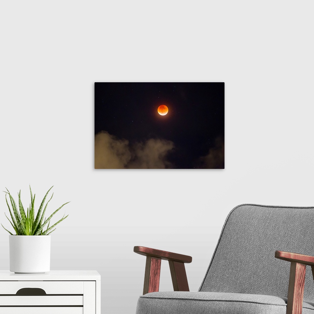 A modern room featuring A break in the clouds reveals a rare lunar eclipse, also known as the super moon, or blood moon.