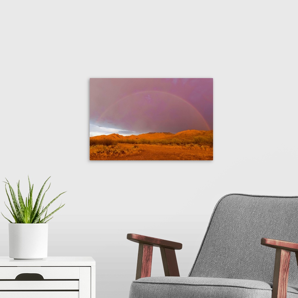 A modern room featuring Rainbow and purple sky on the backside of thunderstorm in a desert.