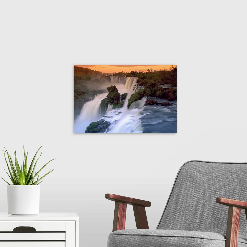 A modern room featuring This wall art is a landscape photograph taken from above of an enormous South American waterfall ...