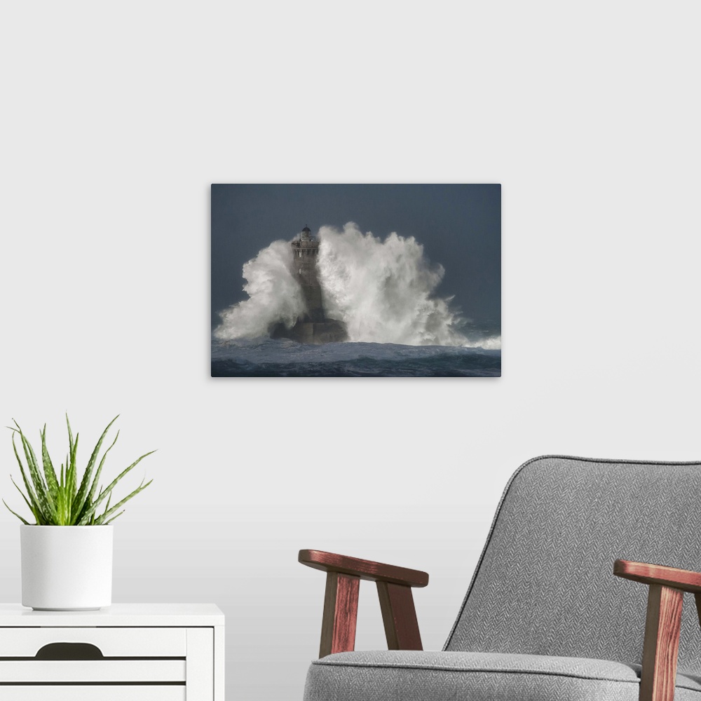 A modern room featuring A photograph of a lighthouse in France being hit with crashing waves.