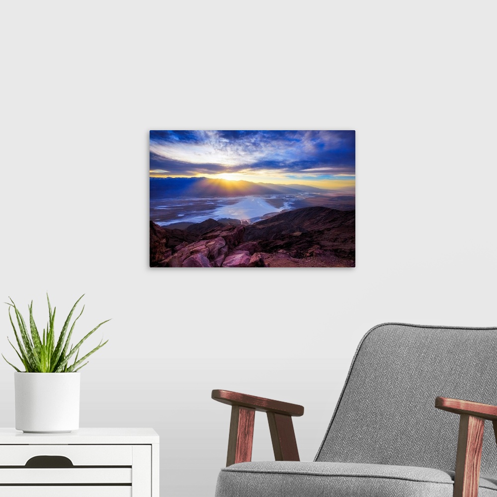 A modern room featuring A photo of a sunset over a valley and mountain.