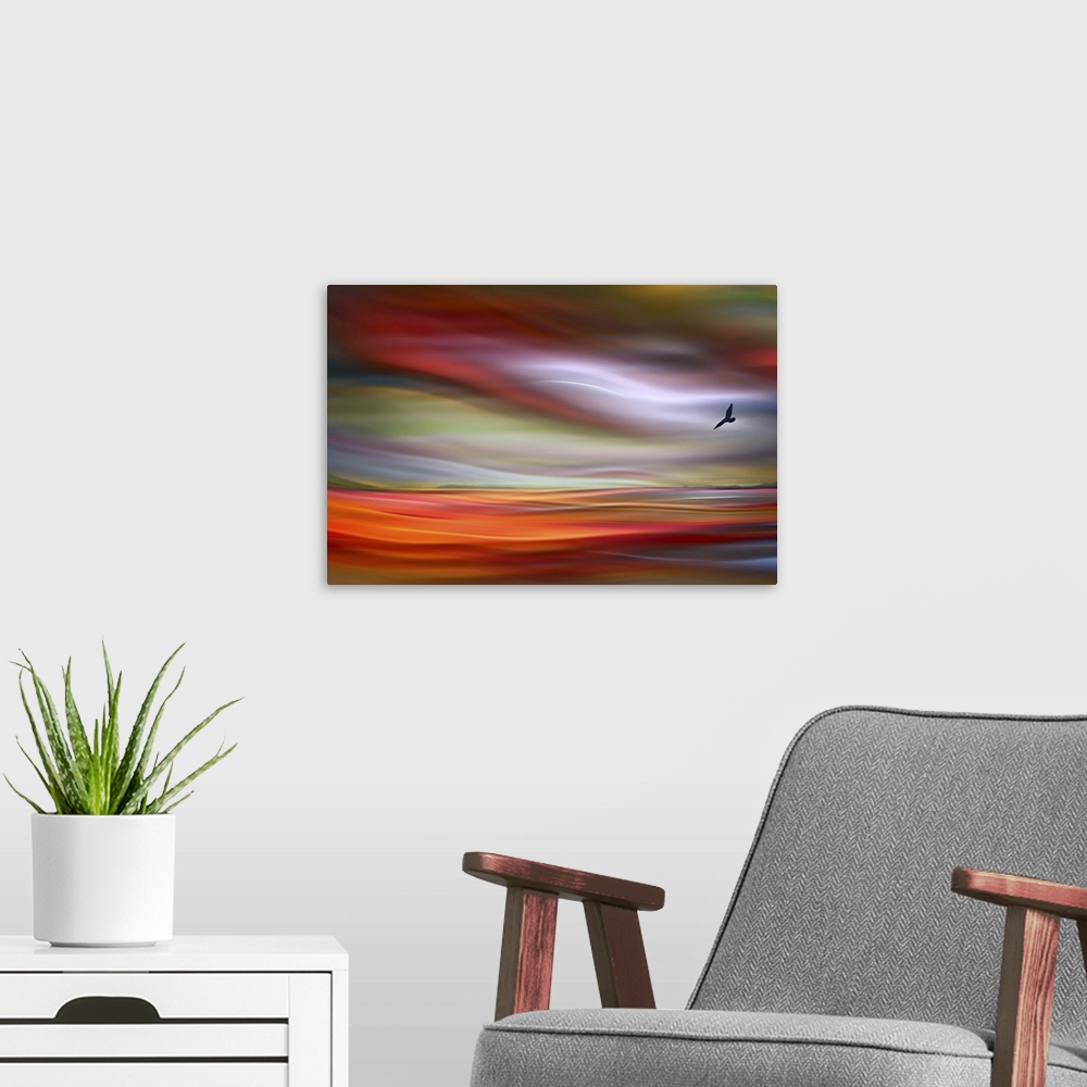 A modern room featuring An abstract photograph of a bird silhouette against a wavy colorful sky.