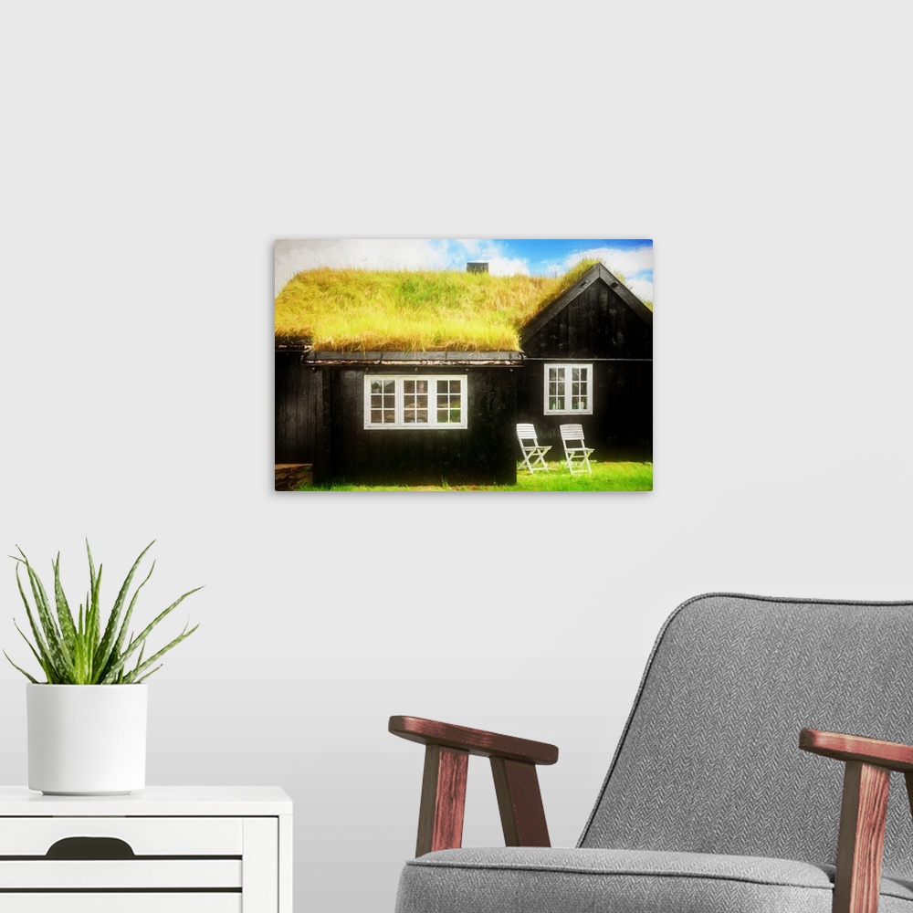 A modern room featuring A black house with white framed windows and a grassy roof.