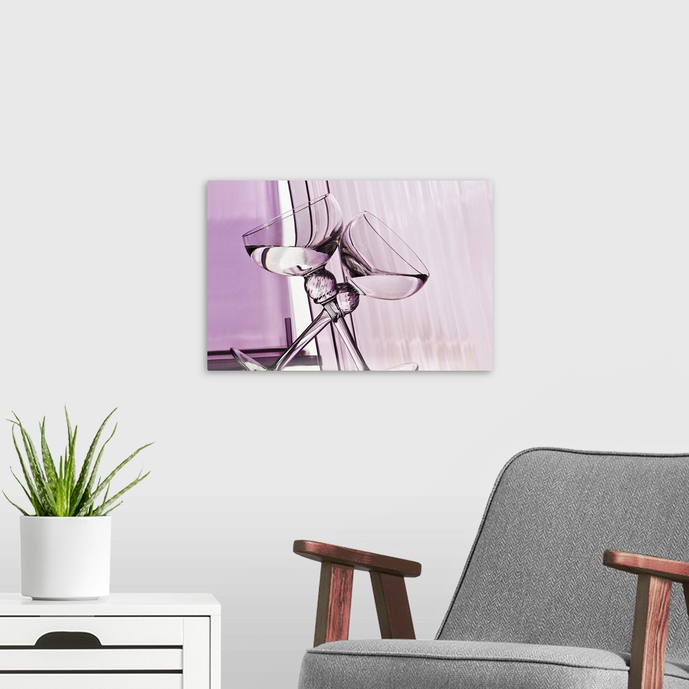 A modern room featuring A photograph of two leaning wine glasses forming an X against an abstract purple background.