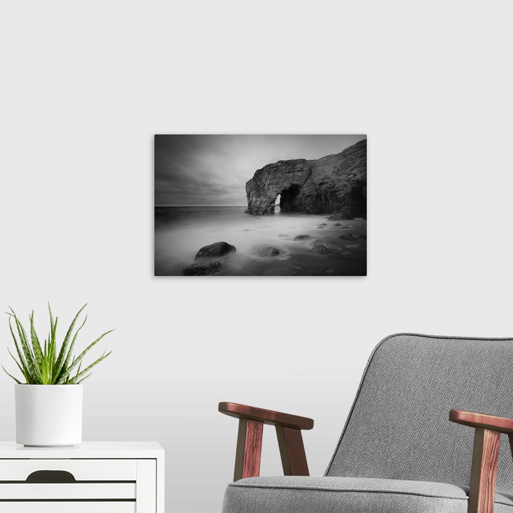 A modern room featuring The natural arch rock in Quiberon island in Britany at high tide, a long black and white time exp...