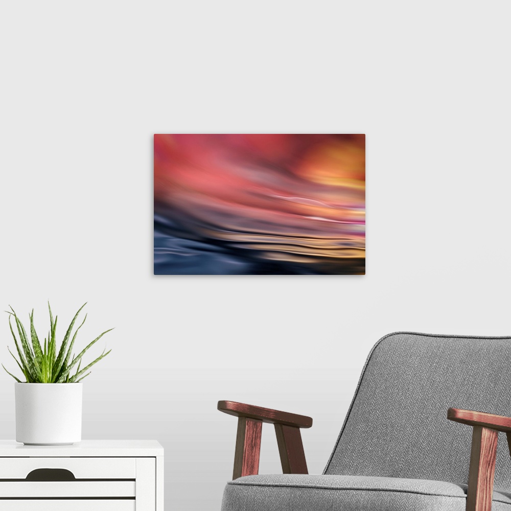 A modern room featuring Abstract photograph of softly rippling water in red and orange tones.