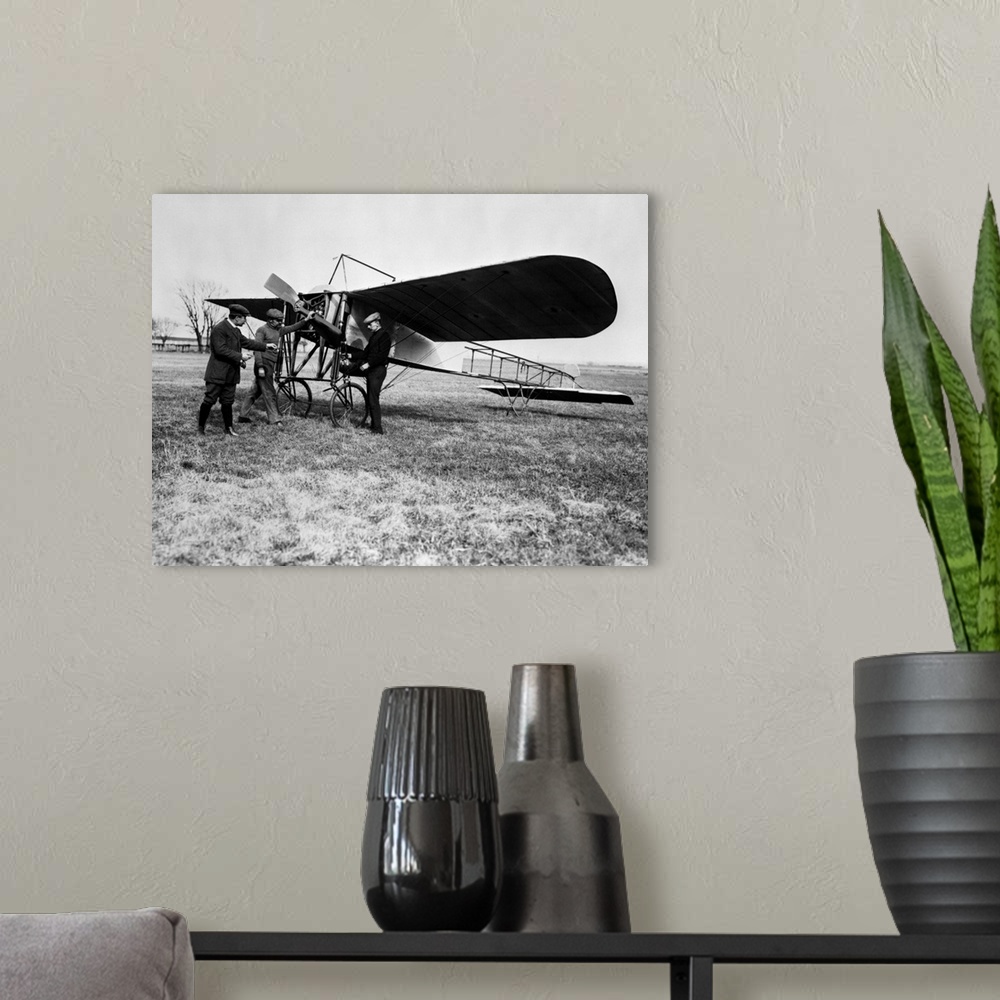 A modern room featuring 1910's Group Of Three Men Standing In Front Of Early Monoplane One With Hand On Propeller.