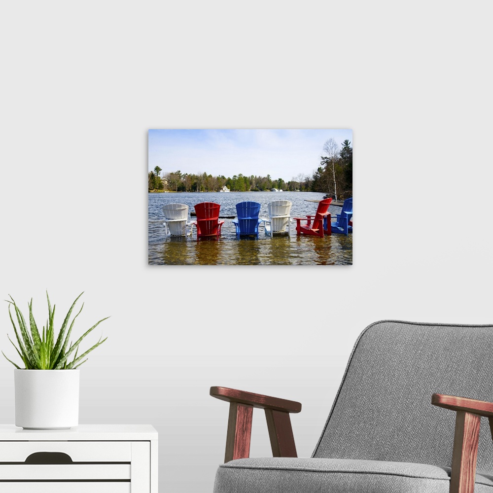 A modern room featuring Adirondack chairs partially submerged in the Lake Muskoka, Ontario, Canada
