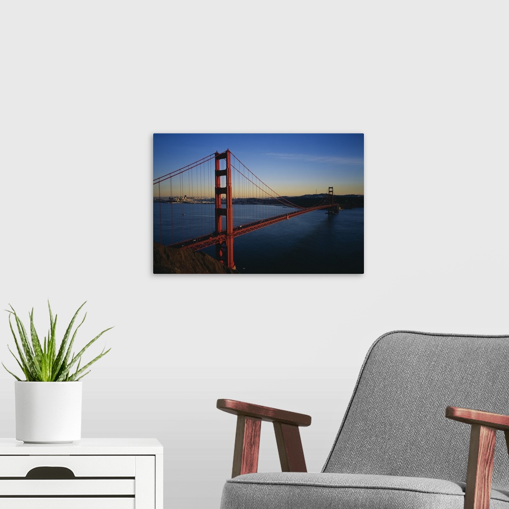 A modern room featuring Photograph of overpass crossing the ocean with city in the background.