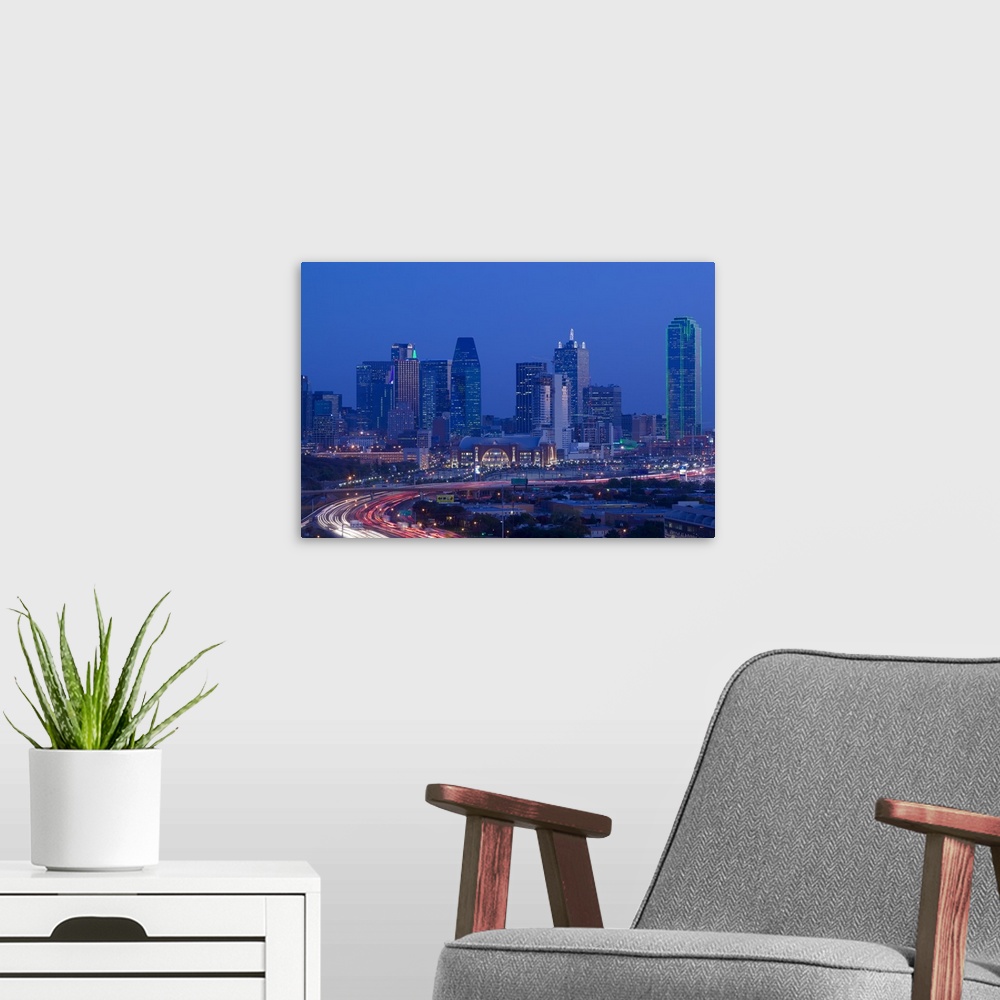 A modern room featuring Big photograph of downtown Dallas, Texas (TX) at night with a busy road in the foreground in fron...