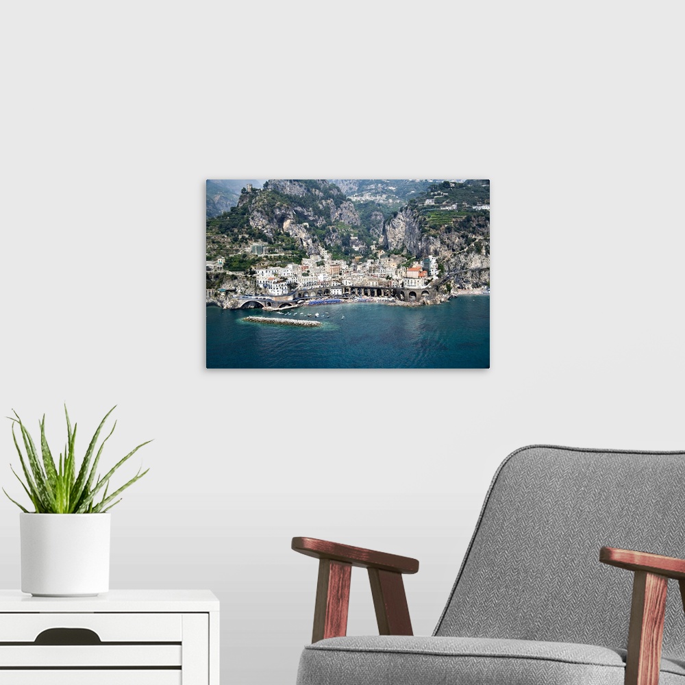 A modern room featuring This decorative wall art is an aerial photograph of an Italian village and harbor build into stee...