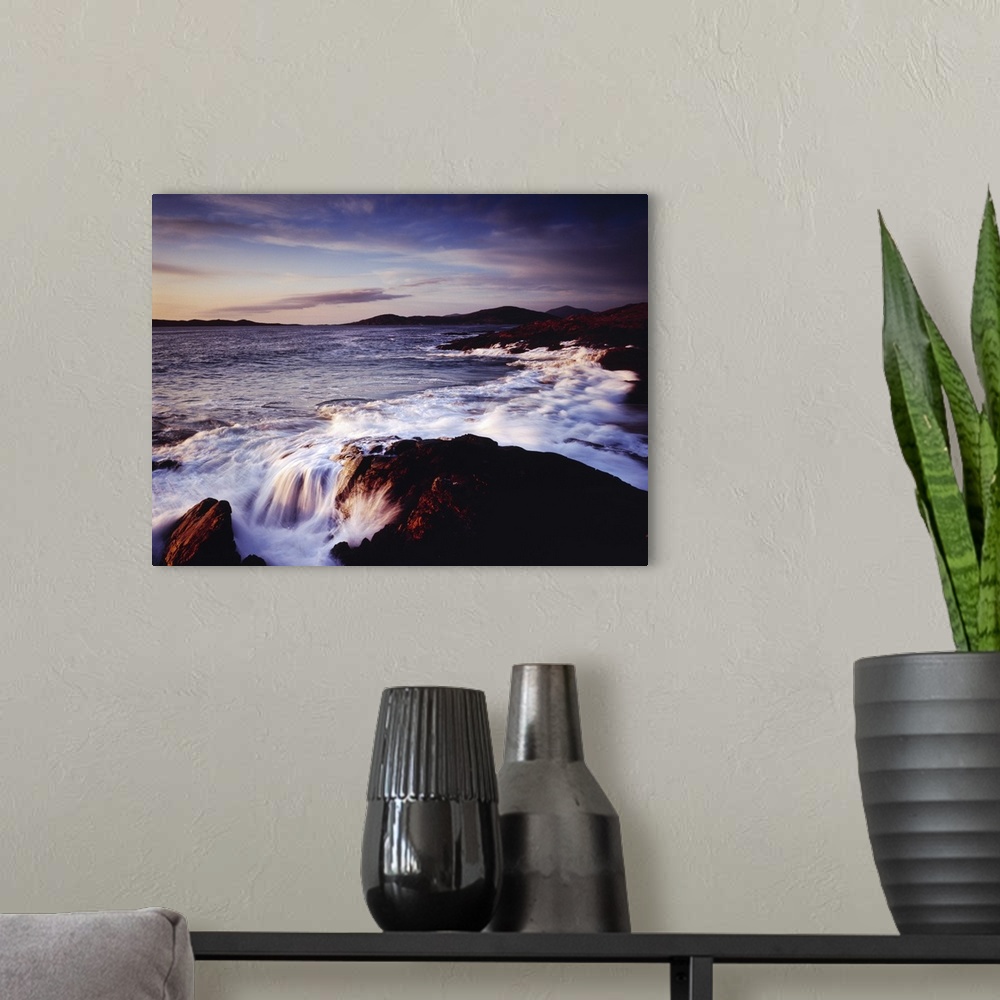 A modern room featuring Horizontal photograph of water crashing into the rocky shoreline of Outer Hebrides as the sun set...