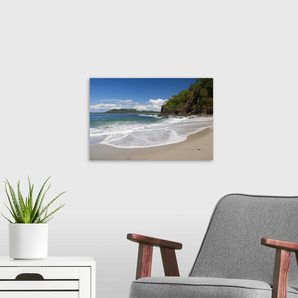A modern room featuring Big photo on canvas of waves washing onto a tropical beach.