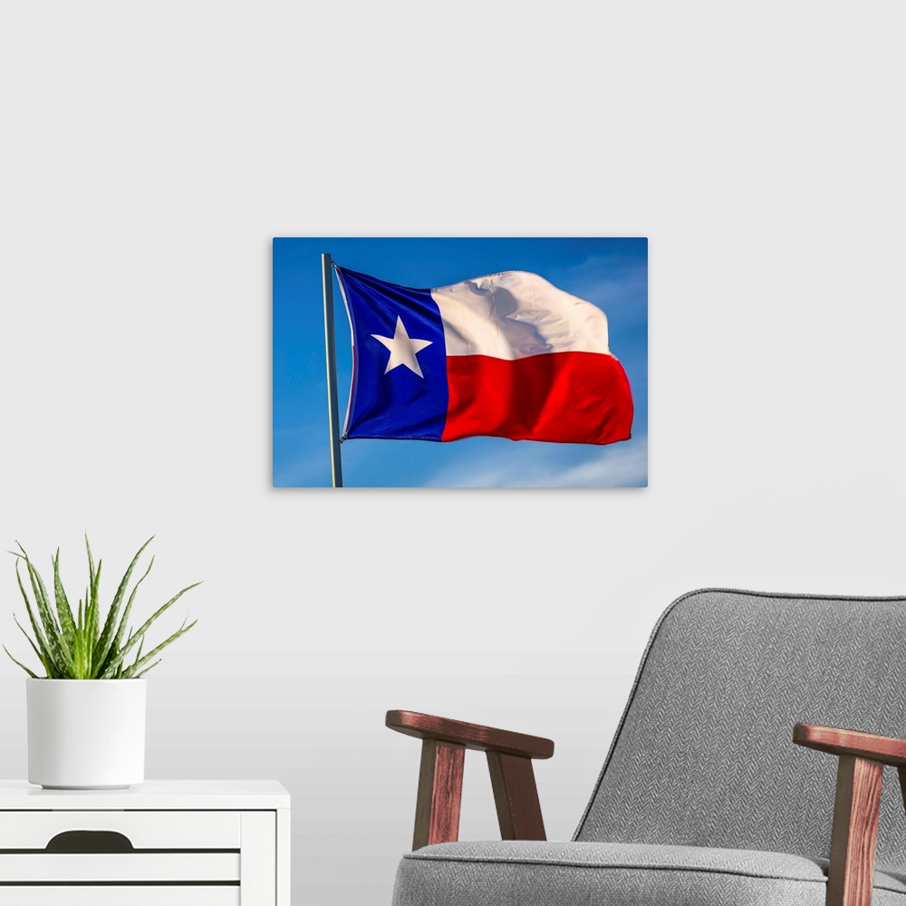 A modern room featuring Texas "lone star" flag stands out against a cloudless blue sky, houston, texas.