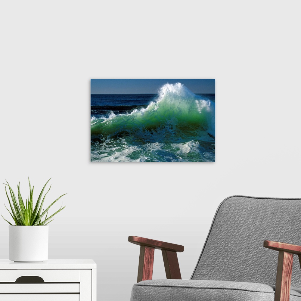 A modern room featuring This wall art for the office or home is a landscape photograph of a wave breaking near the shore.