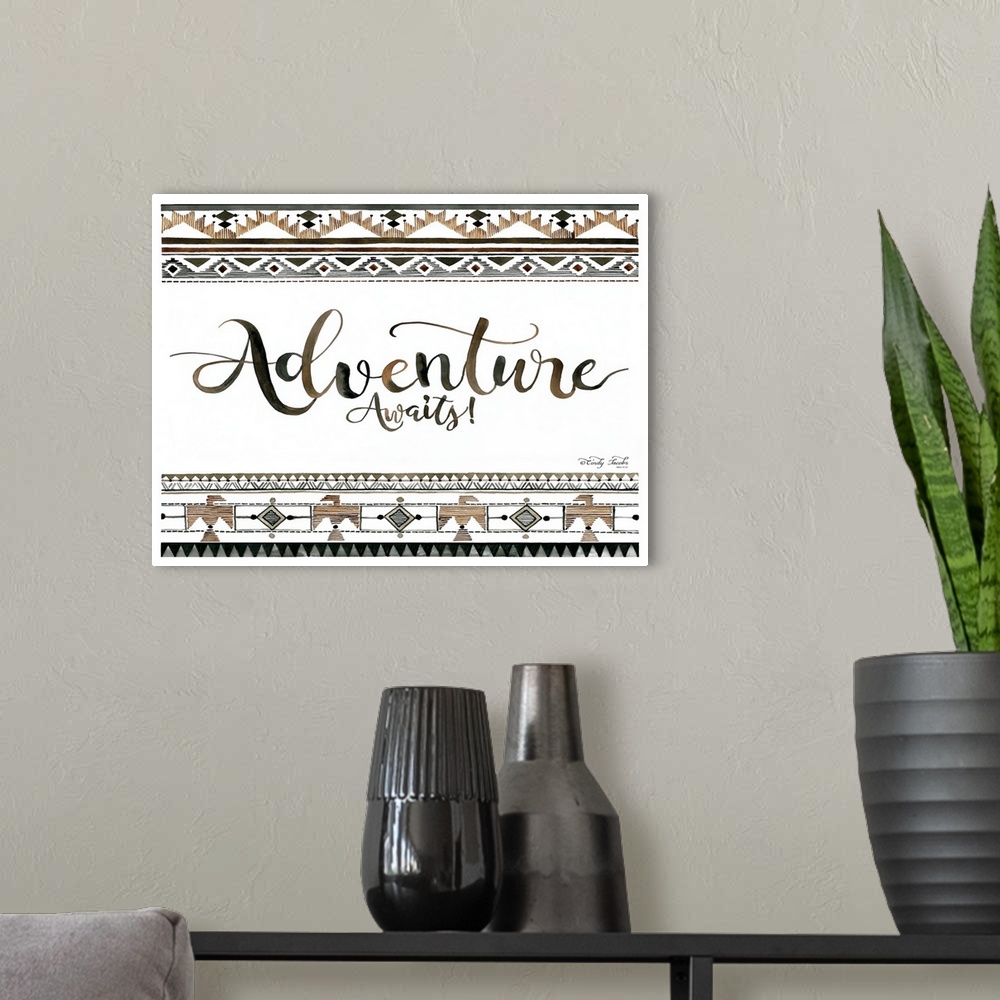 A modern room featuring Decorative artwork featuring geometric southwestern designs and the words: Adventure Awaits!