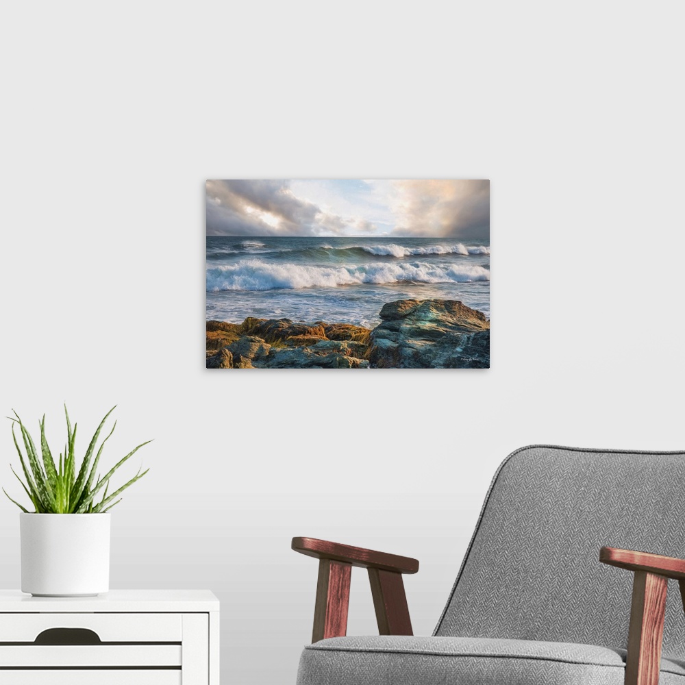 A modern room featuring Rolling waves in the ocean, seen from the rocky shore, with pastel clouds overhead.