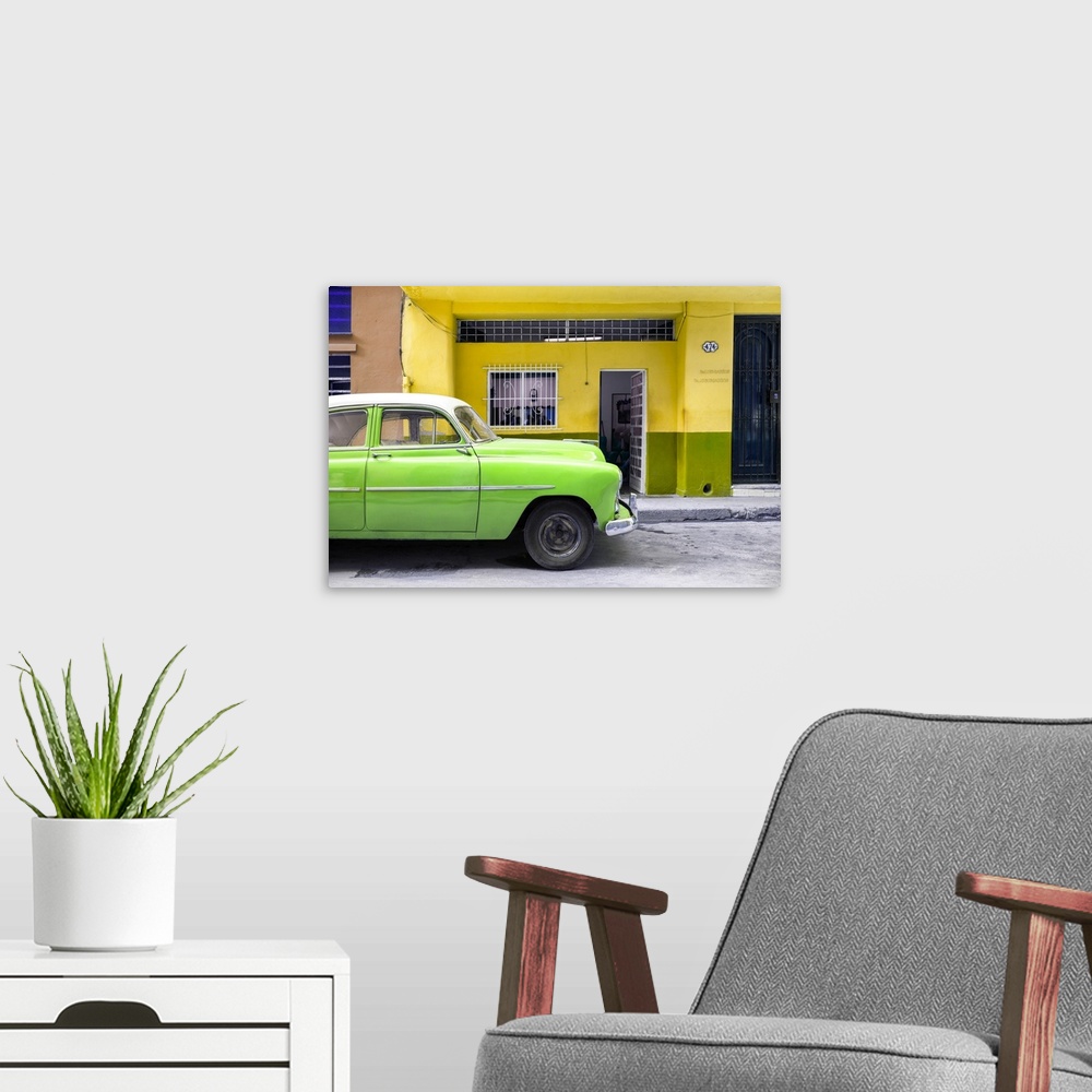 A modern room featuring Photograph of a bright green vintage car parked on the road in Havana with a bright yellow facade...