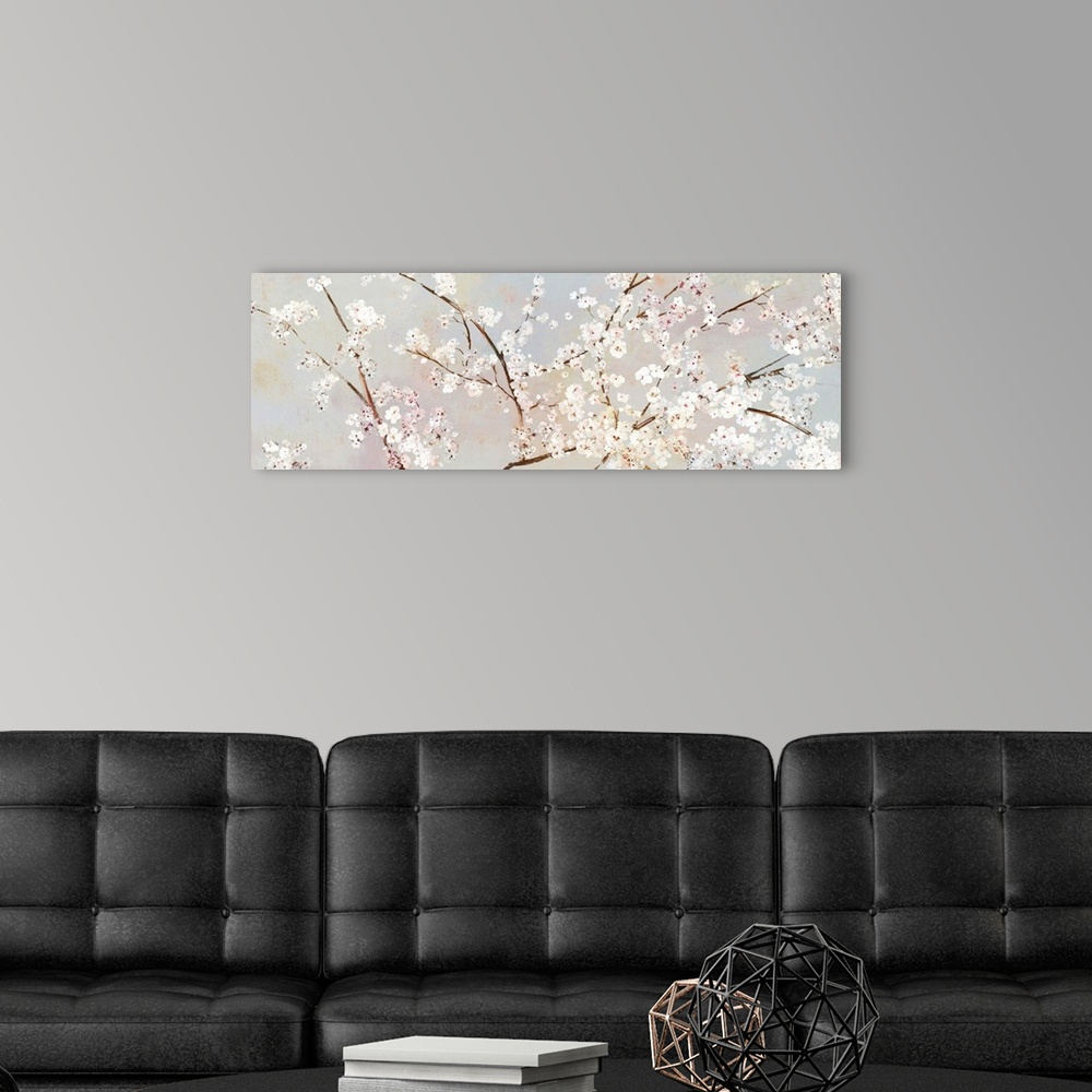A modern room featuring A long panoramic painting of a large branch of white cherry blossoms.