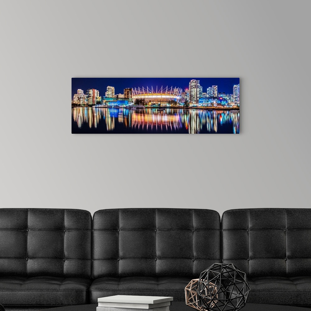 A modern room featuring Panoramic photograph of BC Place Stadium and part of the Vancouver skyline lit up at night and re...
