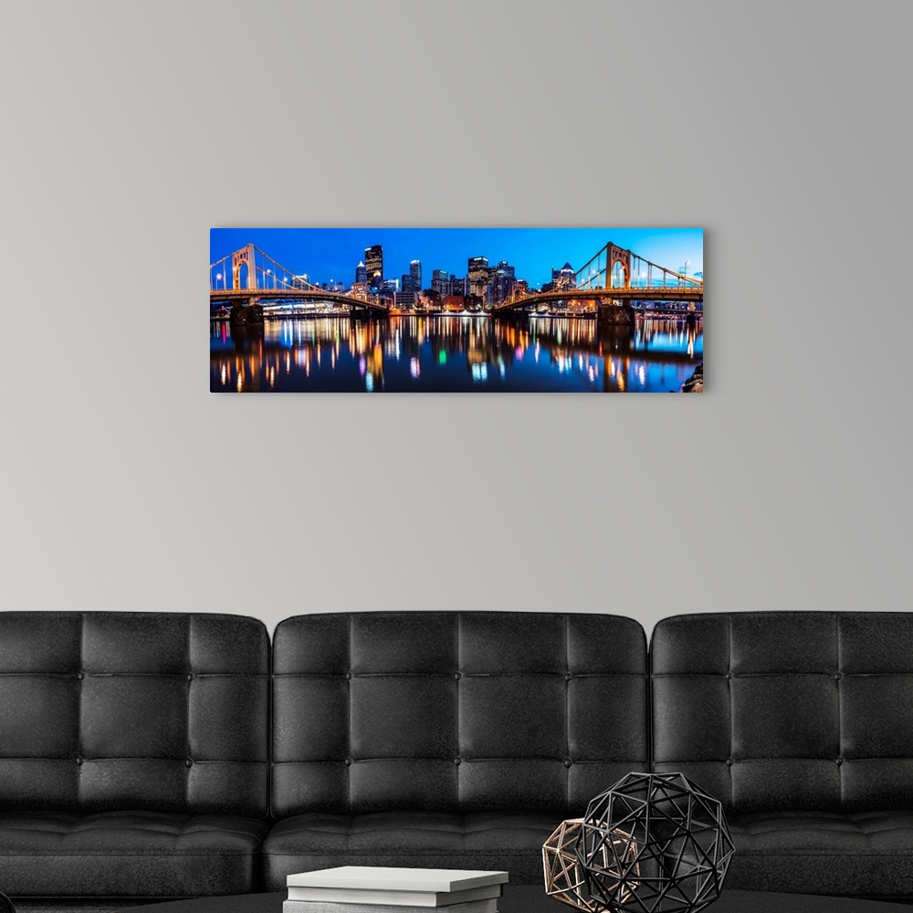 A modern room featuring Panoramic photo of downtown Pittsburgh at night with the Rachel Carson Bridge and the Andy Warhol...
