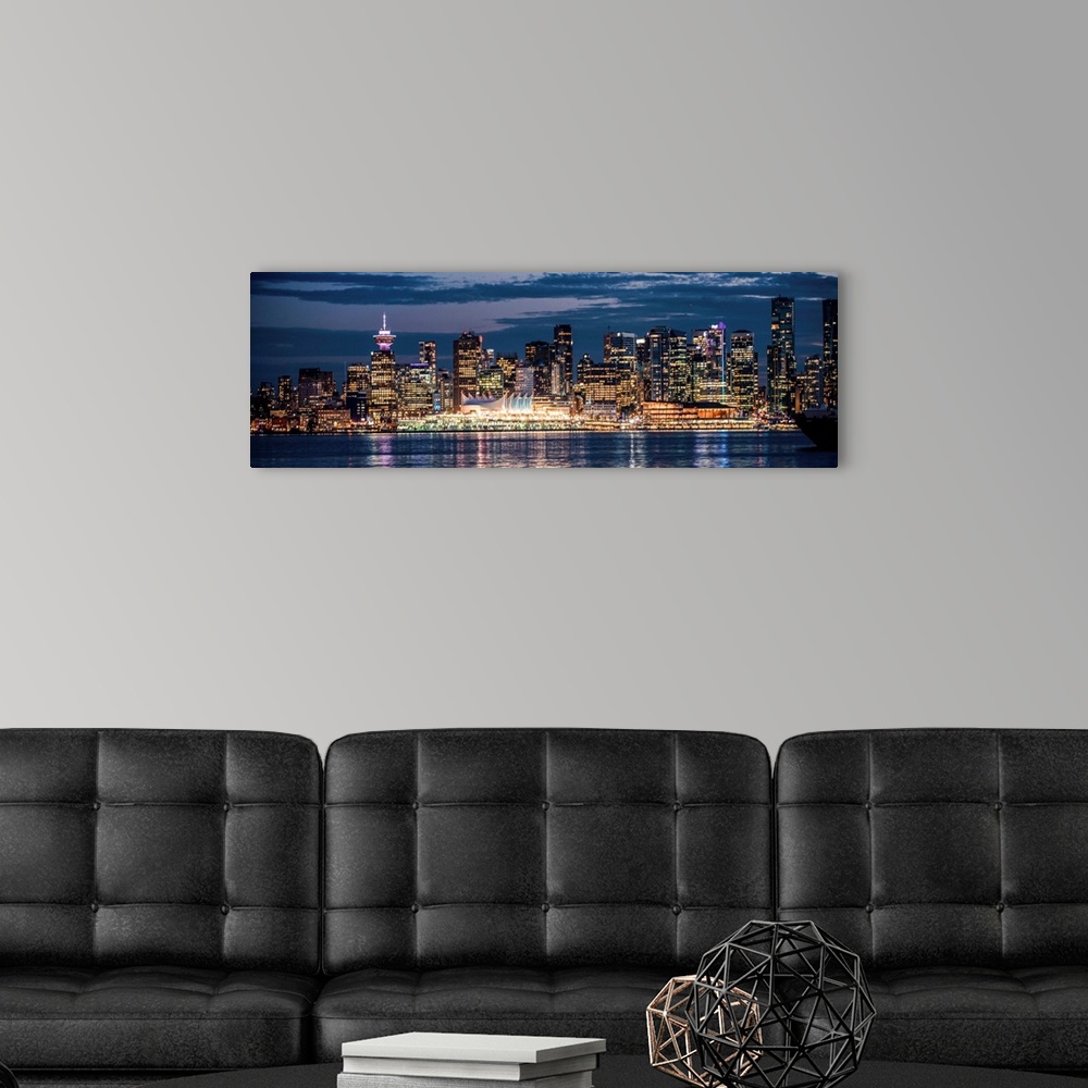 A modern room featuring Panoramic photograph of the Vancouver, British Columbia skyline lit up on a dark blue night and r...