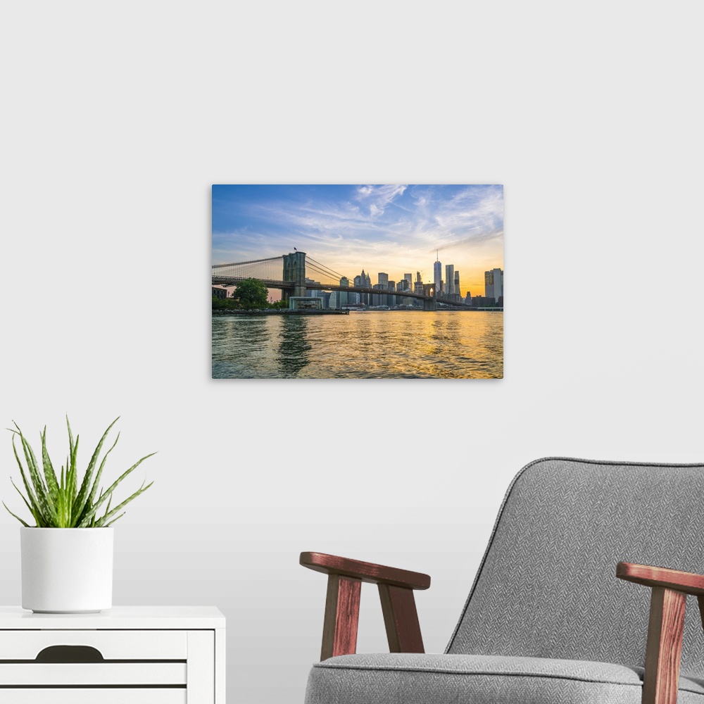 A modern room featuring Brooklyn Bridge and Manhattan skyline at dusk, viewed from the East River, New York City