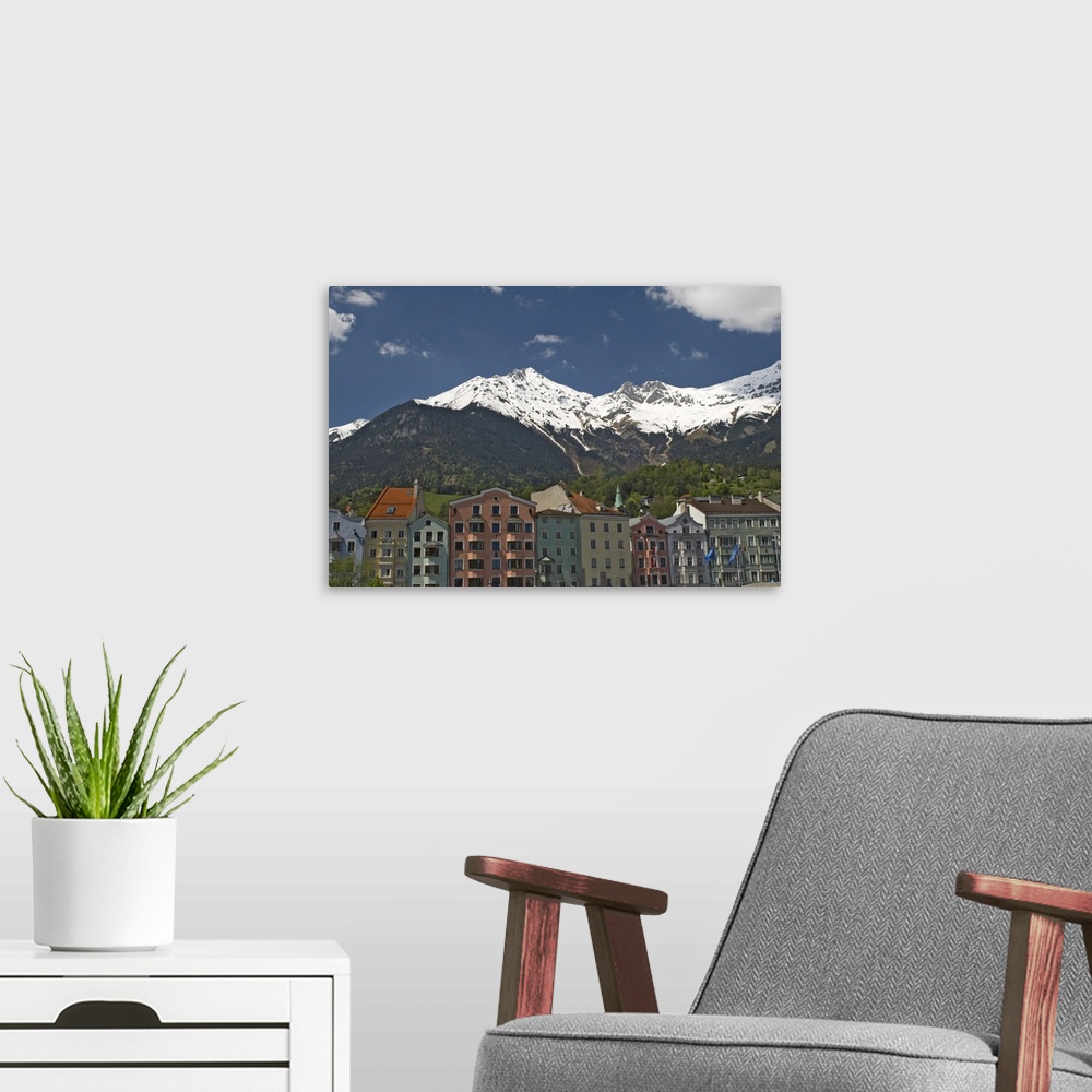 A modern room featuring Candy coloured houses with backdrop of mountains in spring snow, Innsbruck, Austria