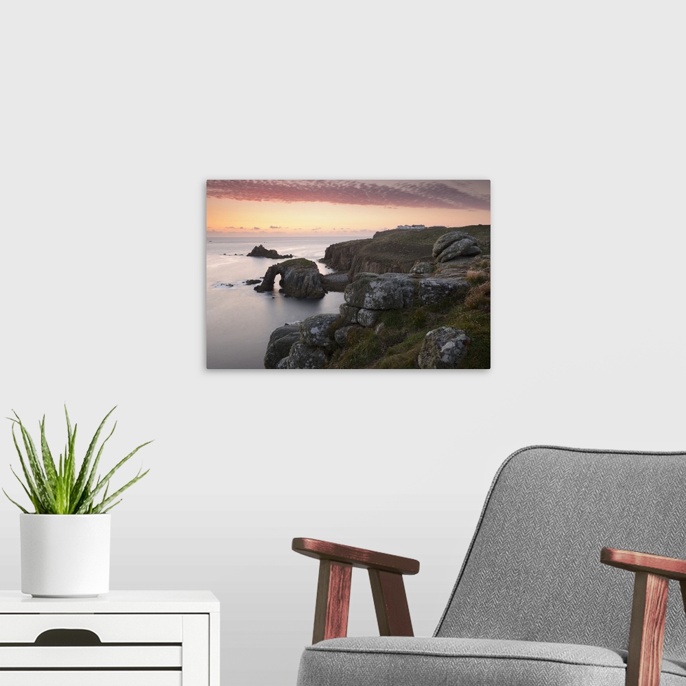 A modern room featuring A colourful sunset overlooking the islands of Enys Dodnan and the Armed Knight at Lands End, Corn...