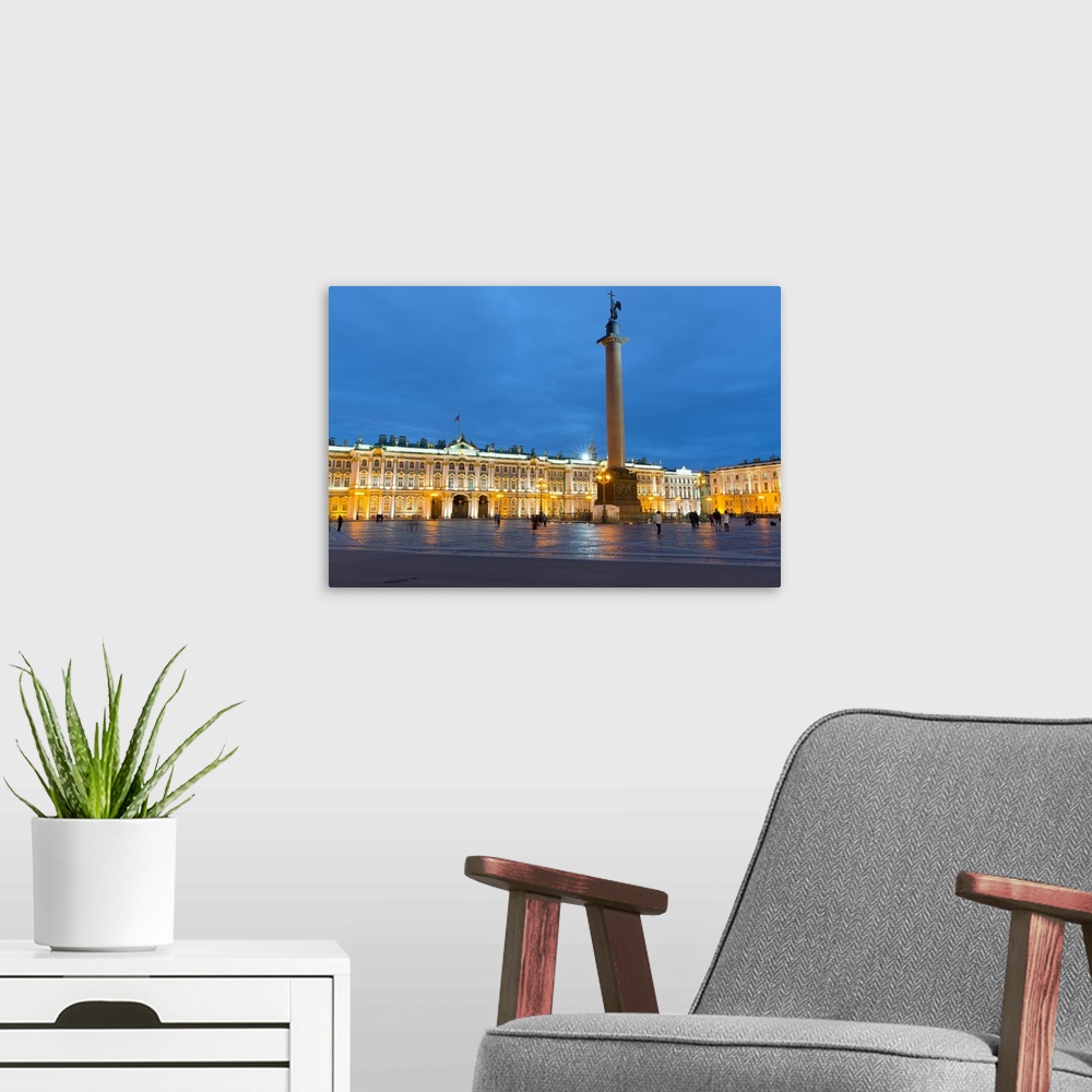 A modern room featuring Dvortsovaya Square with Alexander Column and the Winter Palace of the State Hermitage Museum lit ...