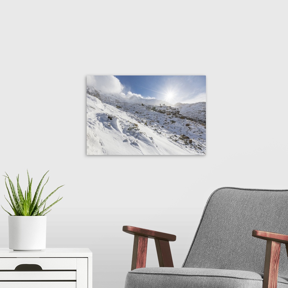 A modern room featuring Hikers proceed in the snowy valley of Alpe Fora, Malenco Valley, Province of Sondrio, Valtellina,...