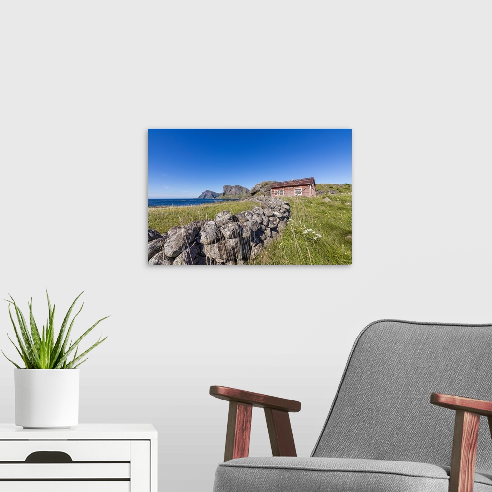 A modern room featuring House of fishermen called rorbu surrounded by sea, Sorland, Vaeroy Island, Nordland county, Lofot...