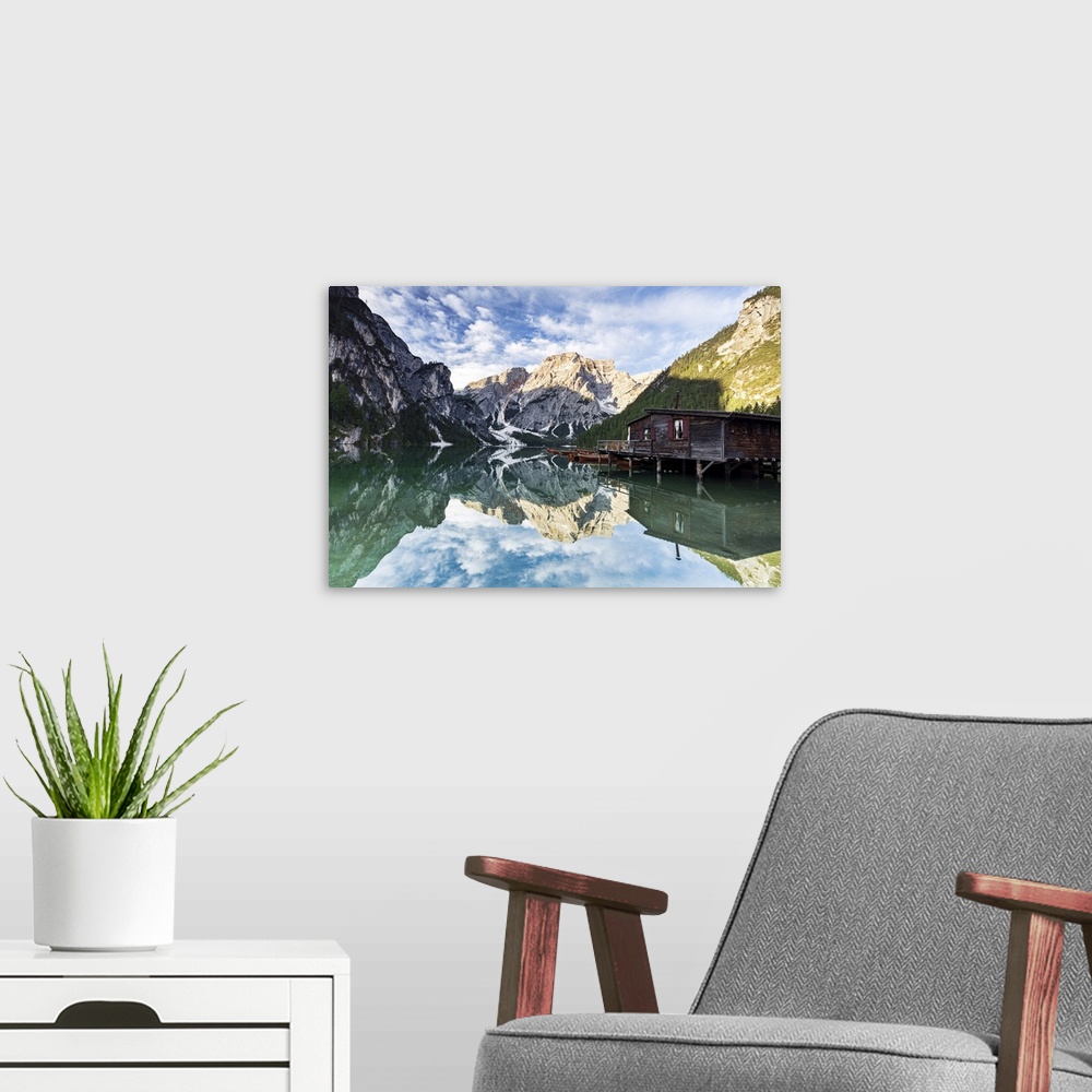 A modern room featuring Lake Braies (Pragser Wildsee) at sunrise with Croda del Becco mountain reflected in water, Dolomi...