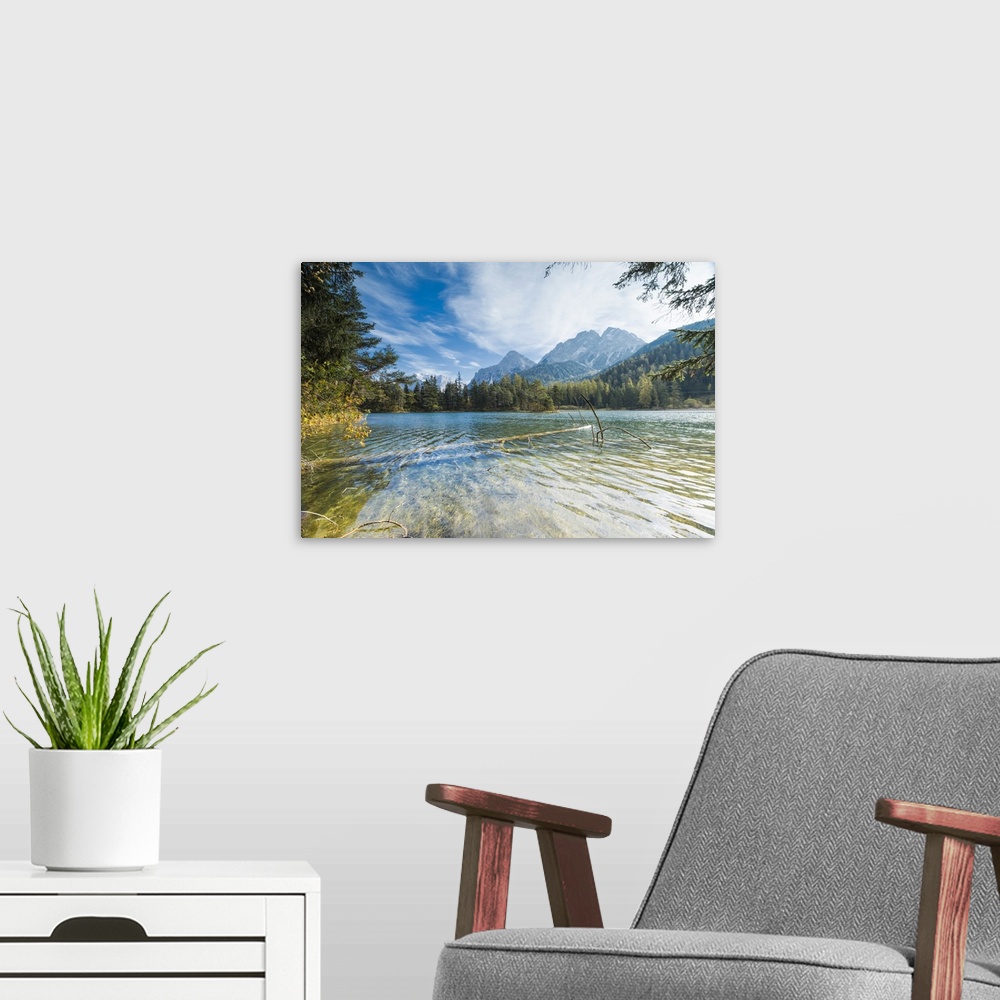A modern room featuring Lake Weissensee surrounded by woods with the Alps in the background, Biberwier, Carinthia, Tyrol,...