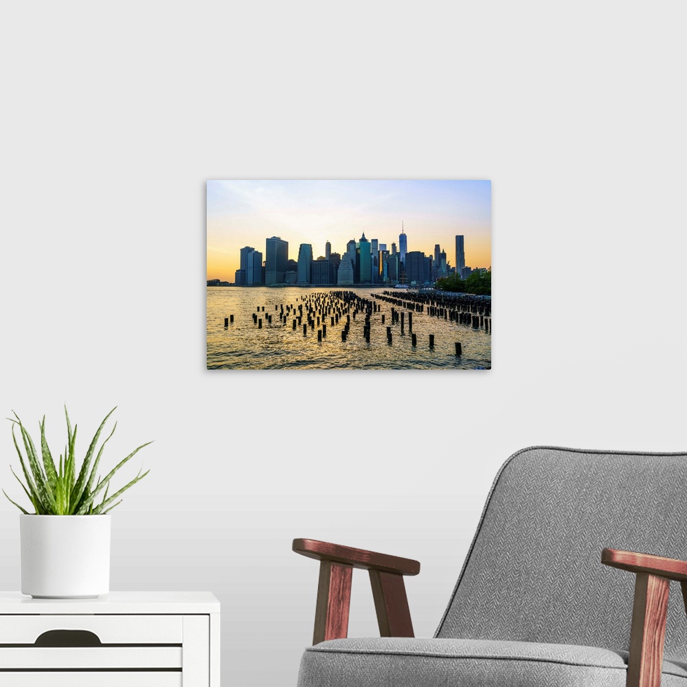 A modern room featuring Lower Manhattan skyline across the East River at sunset, New York City, New York, United States o...